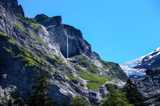 mountains around grindelwald in Switzerland, with mountain and waterfall