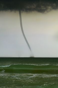 bad weather and storm with the wind on the sea. tornado over the ocean, nature force background - huge tornado, bright lightning in dark stormy sky