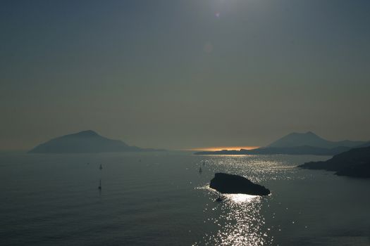 sunset in greece with ocean and greek islands and reflection in sea