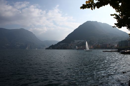 Lake in Lugano with mountains and fountain, with lake and mountains