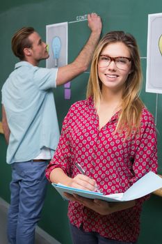 Young creative business people at work against blackboard at office