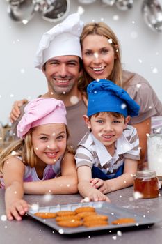 Happy children and parents eating biscuits with snow falling