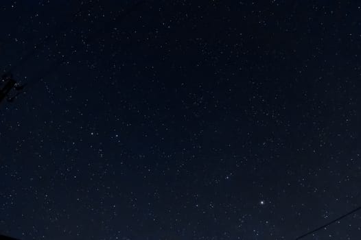 Long exposure night photo of a bright stars. A lot of stars with constellations. Far from the city. Night landscape.