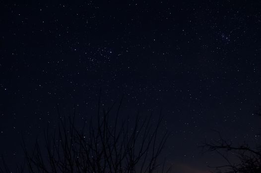 Long exposure night photo of a bright stars. A lot of stars with constellations. Far from the city. Night landscape.