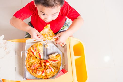 Hot Homemade, Vegetarian fast Italian food, Top view of Cute Little Child enjoying eating Delivery Pizza pepperoni, cheese many slices deliciously in a cardboard box at home with copy space for text