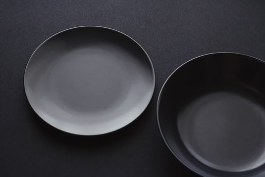 Empty plates on black background, premium dishware for holiday dinner, minimalistic design and diet concept