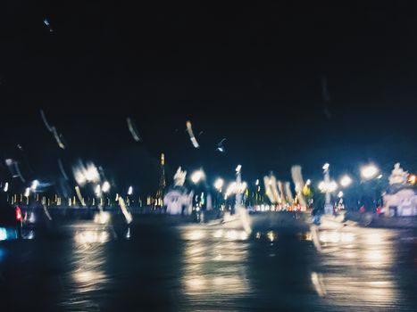 Abstract night city scene in Paris, France, motion blurred lights in the dark