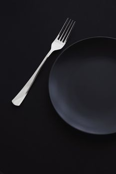 Empty plates and silverware on black background, premium tableware for holiday dinner, minimalistic design and diet concept