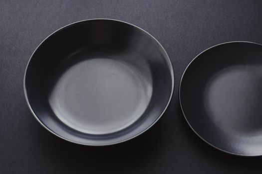 Empty plates on black background, premium dishware for holiday dinner, minimalistic design and diet concept