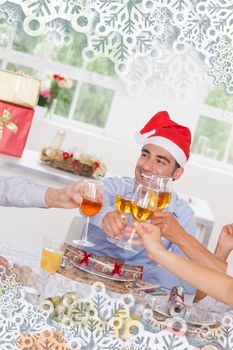 Family toasting at christmas dinner against snowflakes on silver