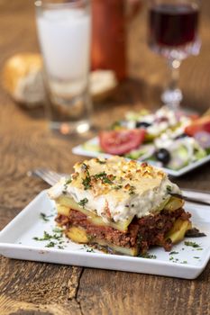 portion of greek moussaka on wood