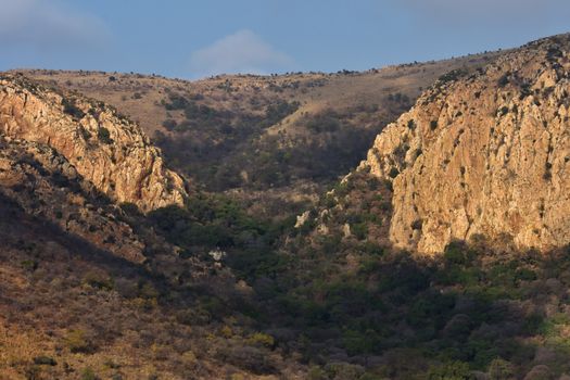 A tree covered mountain pass valley with steep surrounding cliffs, Rustenburg, South Africa