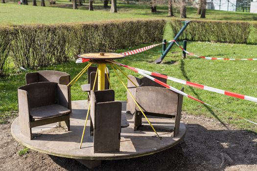 Corona virus COVID-19 restriction. No people due to quarantine. Closed urban skate park. Empty park and playground. Stay at home compaign. Red warning tape on ramps and slides. Social distancing.