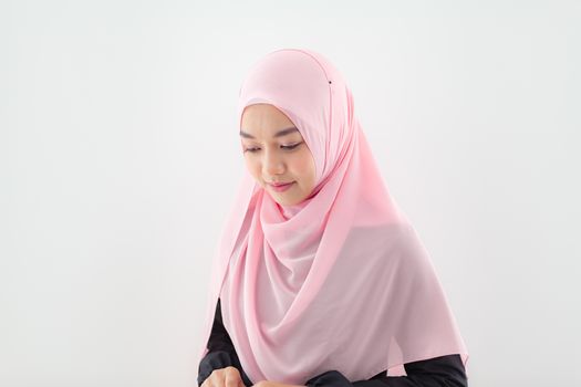 Close up Portrait of a beautiful Muslim Asian woman in a pink hijab on white background.