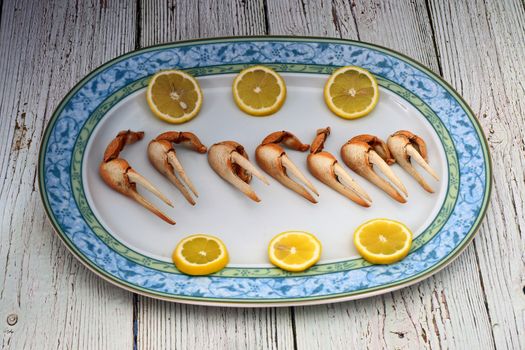 Cooked fiddler crab claws and lemon wedges. Typical Andalusian dish