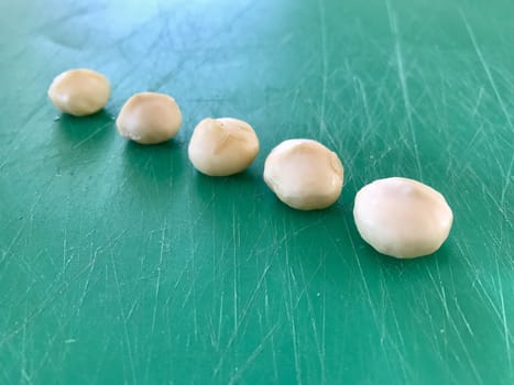 A row of macadamia nuts freshly cracked open
