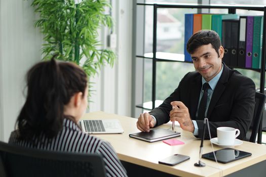 Young employers in black suits are evaluating job applicants by asking marketing strategy questions. Candidate didn't understand what the employer was trying to explain to her.