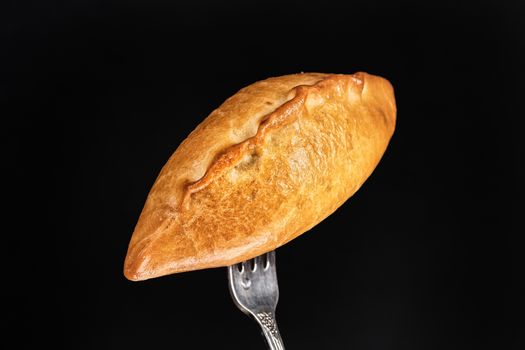 Pie on a fork on a black studio background