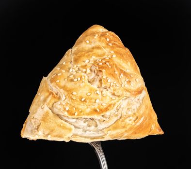 Pie on a fork on a black studio background