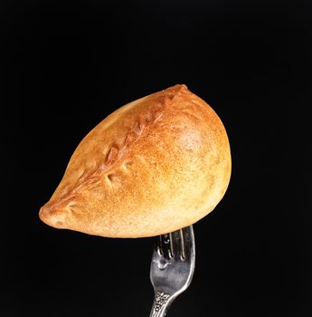 Pie on a fork on a black studio background