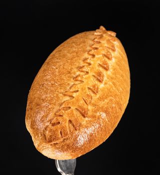 Pie on a fork on a black studio background