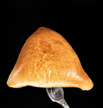 Pie on a fork on a black studio background