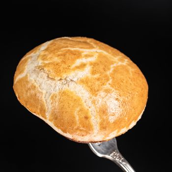 Pie on a fork on a black studio background