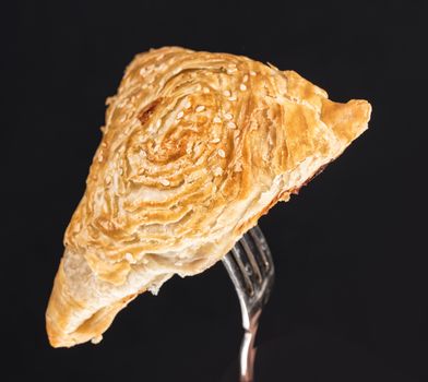 Pie on a fork on a black studio background