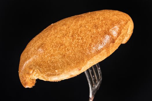 Pie on a fork on a black studio background