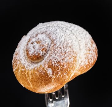 Pie on a fork on a black studio background