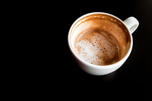 Stain of Hot milk coffee and soft froth inside the white ceramic cup, Half a cup of coffee