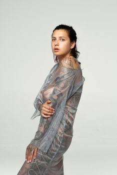 young beautiful girl posing in a transparent dress in the studio