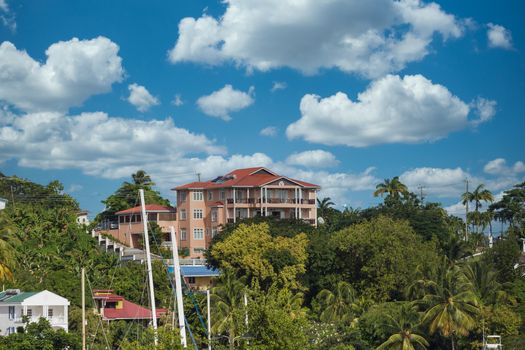 A large stucco resort on a green tropical hill