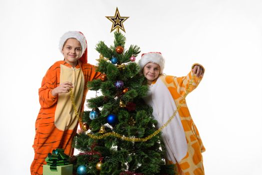 Portrait of two girls in pajamas near the Christmas tree