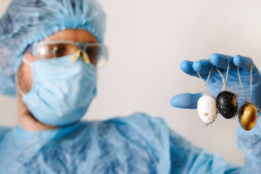 Hands in medical gloves holding modern painted easter eggs. Selective focus. Toned picture.