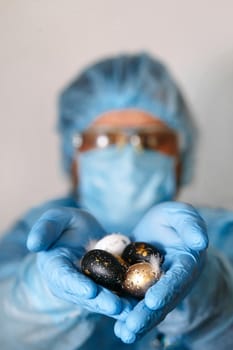 Hands in medical gloves holding modern painted easter eggs. Selective focus. Toned picture.