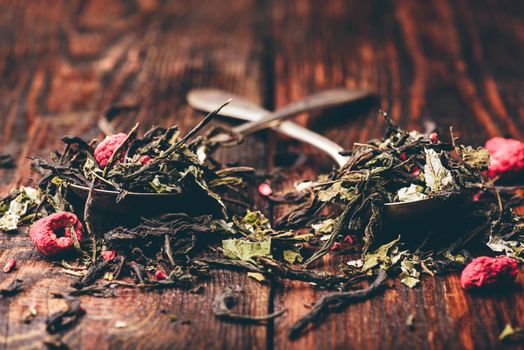 Two spoonfuls of raspberry herbal tea over wooden surface