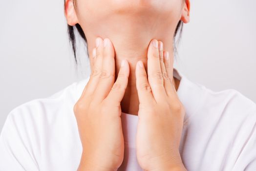 Asian beautiful woman Sore Throat or thyroid gland problem her useing Hand Touching Ill Neck on white background with copy space, Medical and Healthcare concept