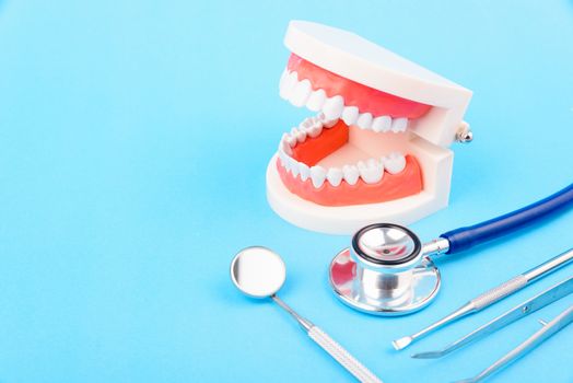 Dental Hygiene Health Concept, White tooth and Dentist tools for dental care on blue background