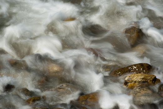 Soft waves on a rocky beach in the morning