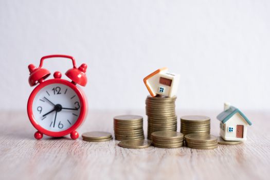 Mini house model and stack of coins. Business risk management. Property investment and house mortgage financial real estate concept 