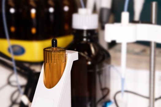 Close-up of a laboratory glass flask with a yellow liquid on a laboratory table for experiments. The concept of scientific research and development.