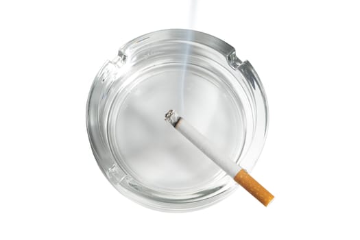 The top view of a cigarette lit in glass ashtray on white