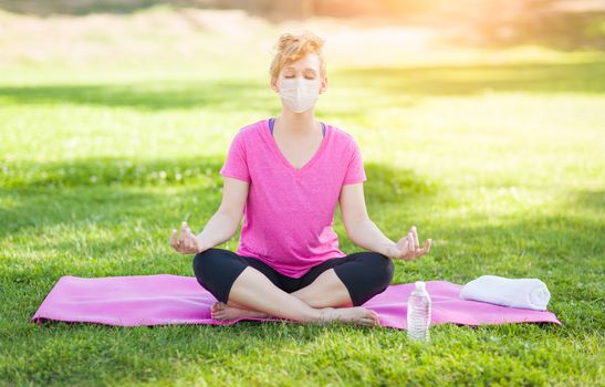 Girl Wearing Medical Face Mask During Yoga Meditation Workout Outdoors.
