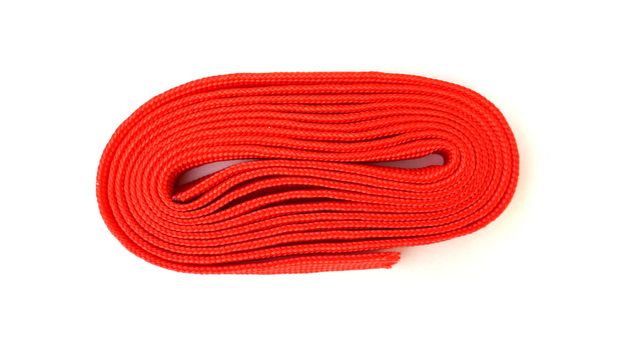 Red rope on white background. Fabric rope in red color folded in a coil.