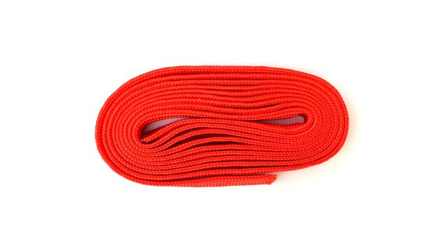 Red rope on white background. Fabric rope in red color folded in a coil.