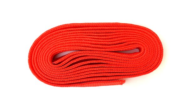 Red rope on white background. Fabric rope in red color folded in a coil.