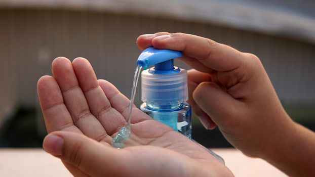 Kid washing hands with anti disinfectant alcohol based gel to protect from corona virus.