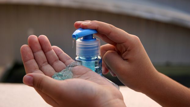 Kid washing hands with anti disinfectant alcohol based gel to protect from corona virus.