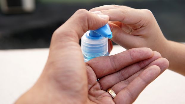 Washing hands with alcohol based gel from a hand pump bottle to protect against corona virus or Covid-19.